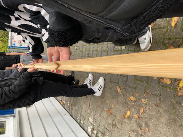 Ein Holzstab und ein Element wird von der Gruppe gehalten