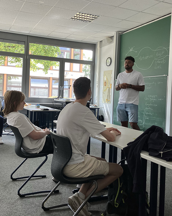 Zwei Schüler sitzen im Klassenraum am Tisch vor dem Trainer