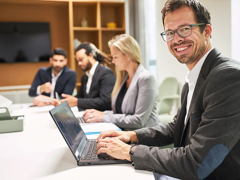 Mann mit Laptop in einer Besprechung