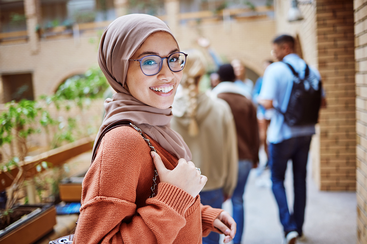 Eine junge Frau mit Kopftuch in einer Schule