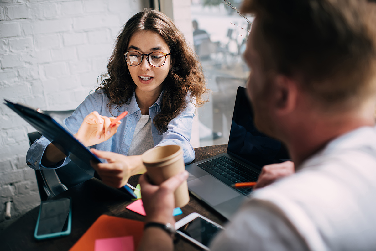 Eine Frau berät an einem Tablet einen jungen Mann