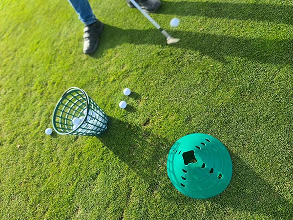 Golfbälle im Korb auf dem Rasen
